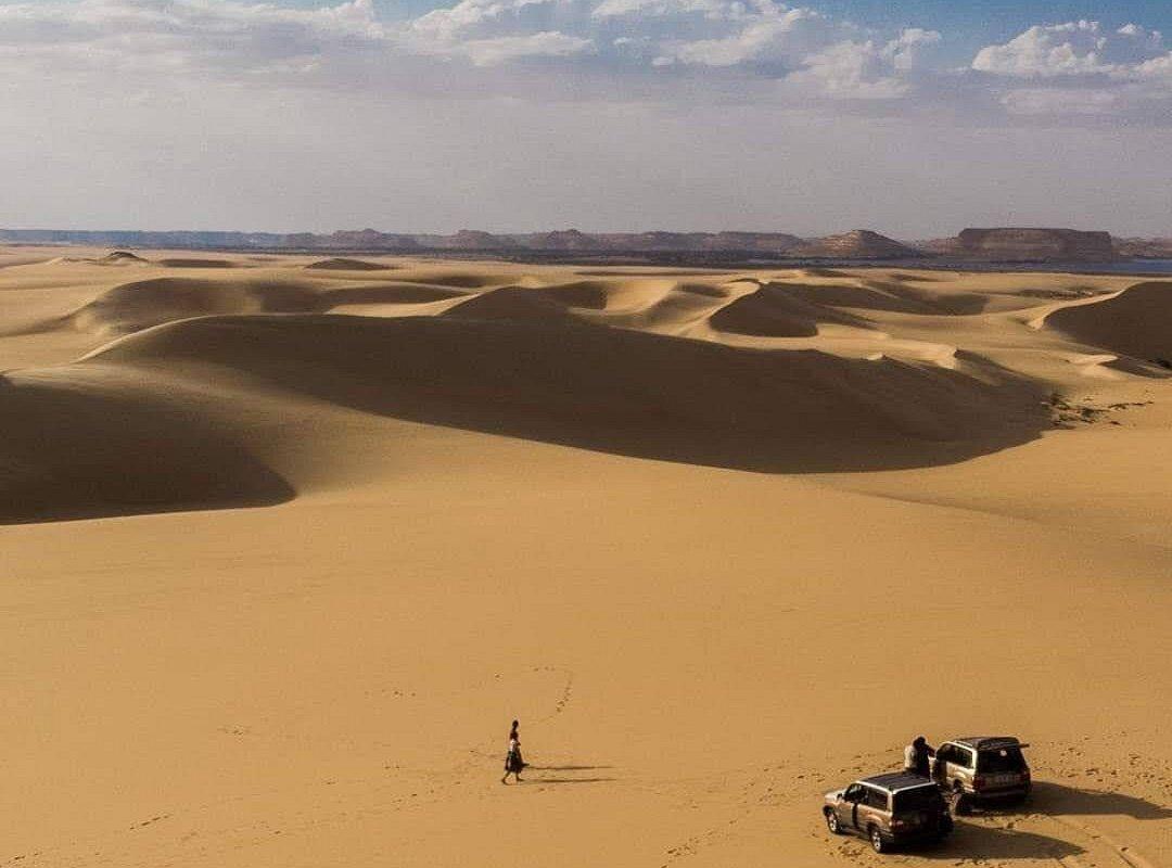 4x4 vehicle crossing tall sand dunes in the Great Sand Sea near Siwa