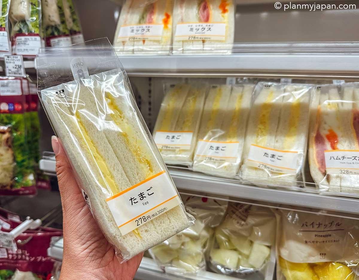 7-Eleven Japan tamago sando egg salad sandwich in triangular packaging on a convenience store shelf