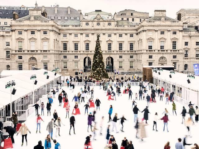 Skaters on the Somerset House ice rink surrounded by the neoclassical courtyard lit with festive lights