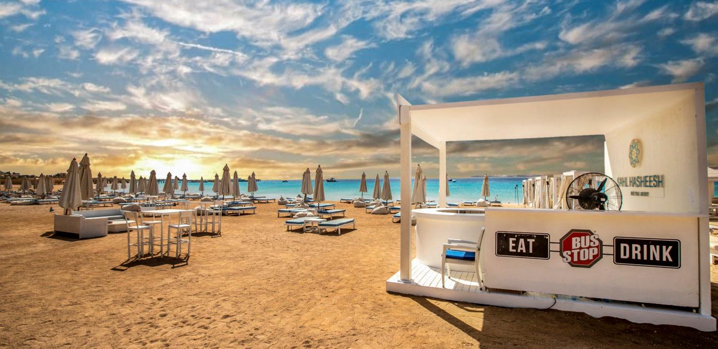 Lit outdoor terrace of The Bus Stop bar on the Sahl Hasheesh promenade at night