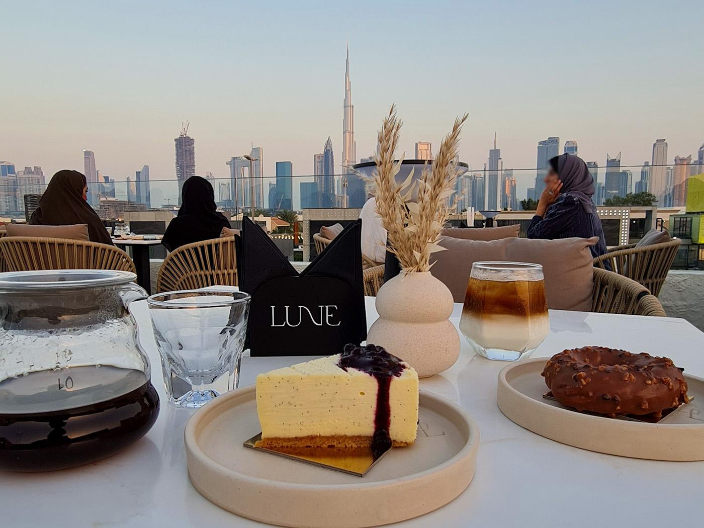 Dubai skyline at night with Burj Khalifa lit up, waterfront promenade, and city lights reflecting on calm water