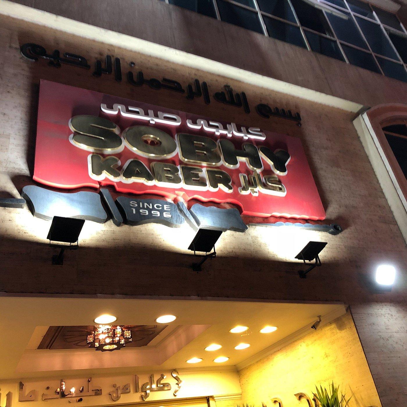 El Fishawy café entrance in Cairo's Khan el-Khalili bazaar, lit by ornate hanging lanterns and glowing Arabic signage at night