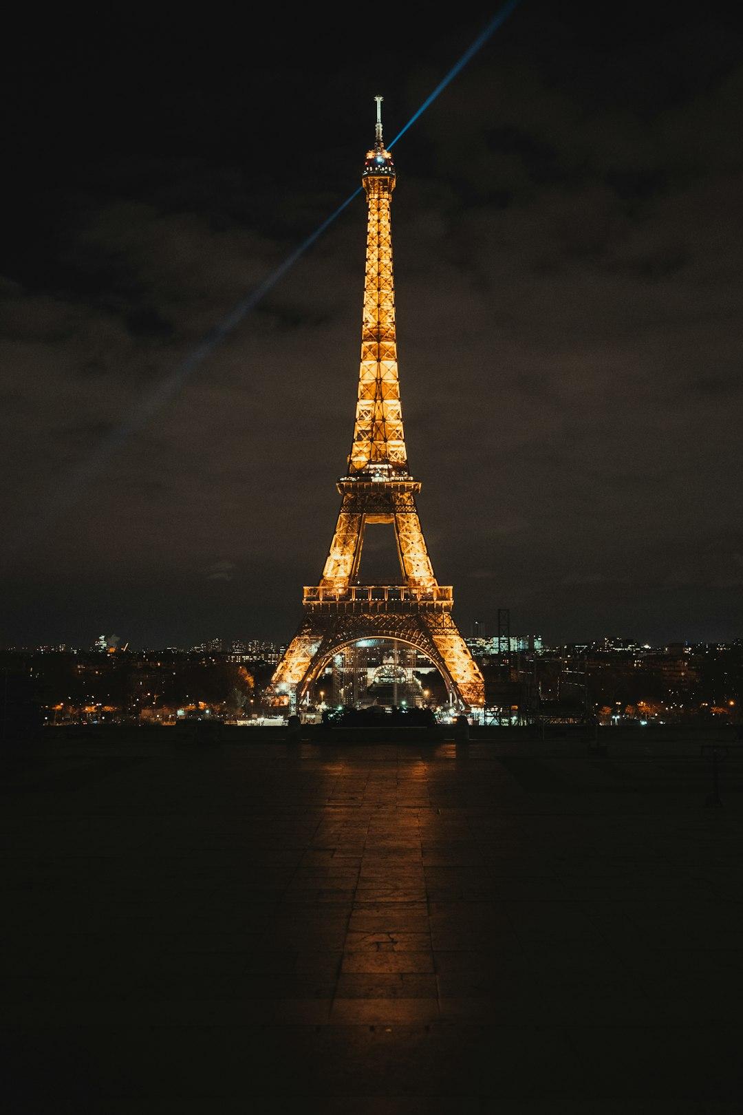 Eiffel Tower rising above the Seine River at dusk, with moored riverboats and a purple-pink cloudy sky, Paris