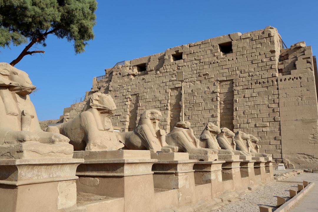 Row of ram-headed sphinx statues lining the entrance to Karnak Temple complex in Luxor, Egypt