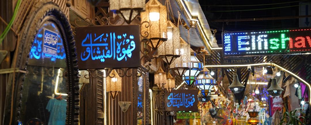 El Fishawy café entrance in Cairo's Khan el-Khalili bazaar with glowing Arabic signs and ornate hanging lanterns