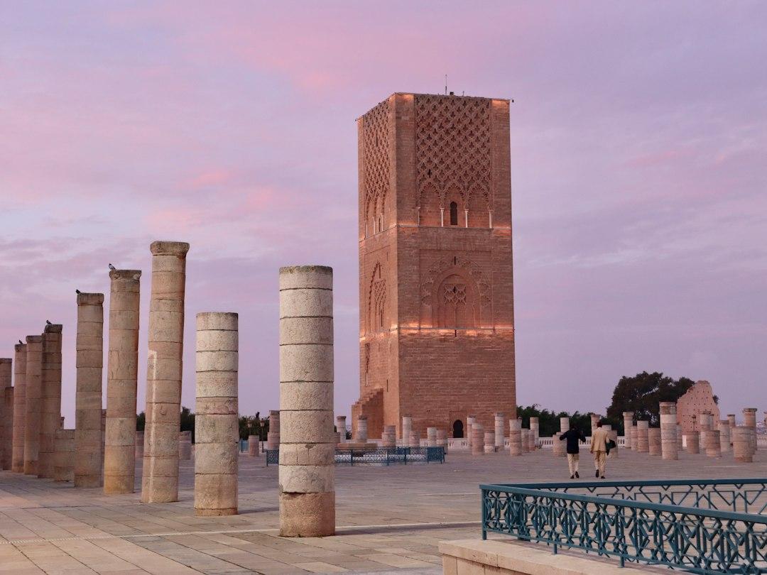 Hassan Tower minaret and ancient stone columns at dusk under a pink-purple sky in Rabat, Morocco
