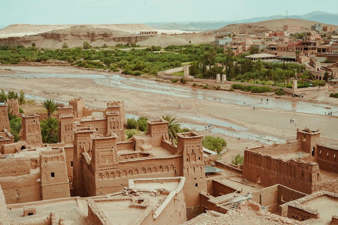 Aerial view of Ait Benhaddou mudbrick ksar with ornate towers beside the sandy Ounila River, Morocco