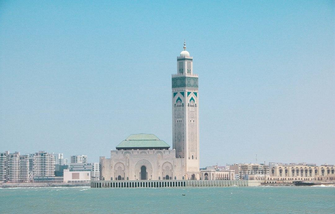Hassan II Mosque with its towering minaret and green-tiled dome rising above the Atlantic Ocean in Casablanca, Morocco