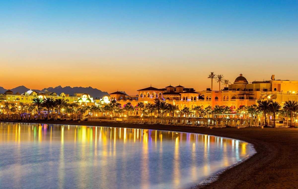 Pedestrian promenade at Old Town Sahl Hasheesh at dusk with lit archways and waterfront cafes