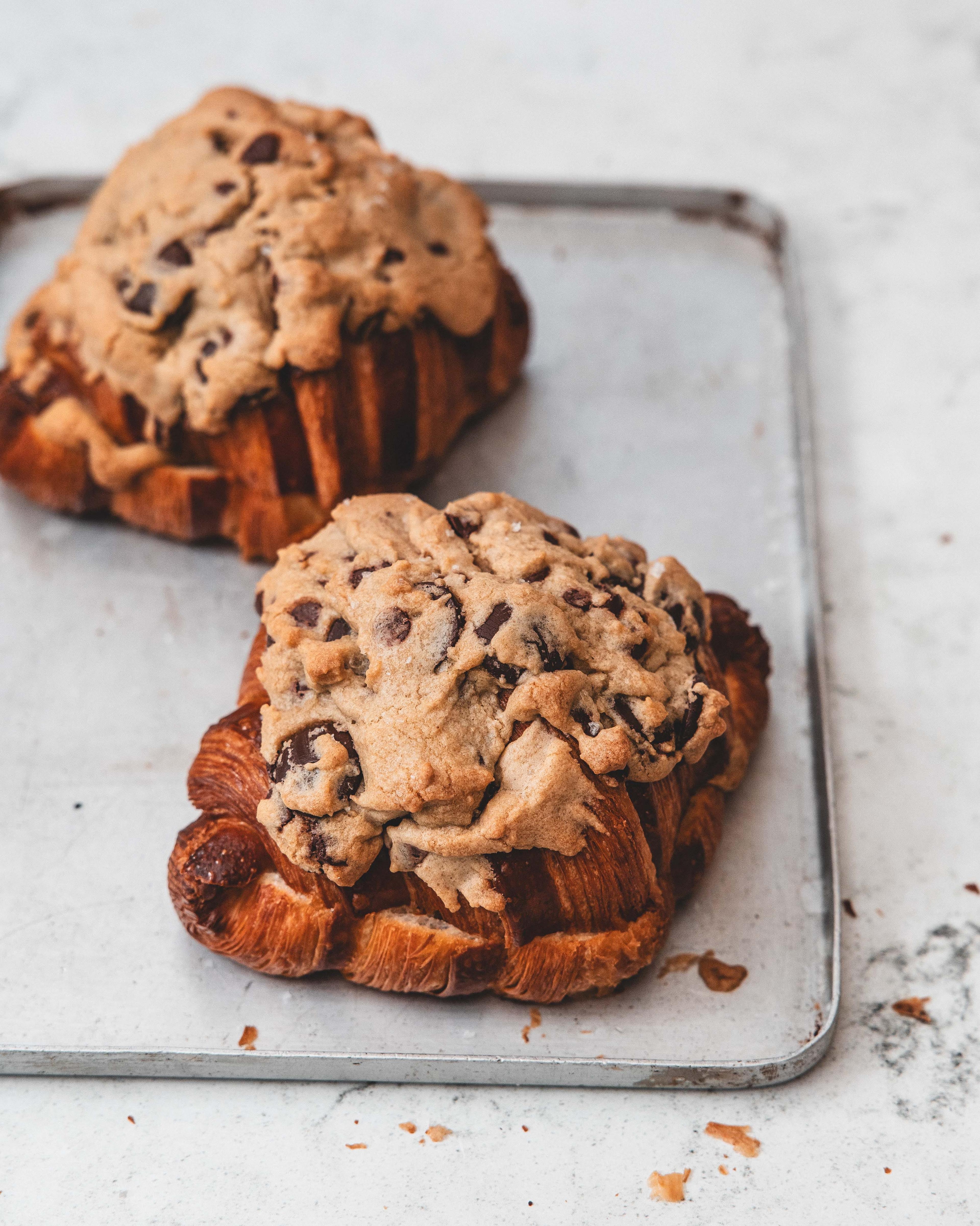 Golden flaky croissants piled high on a ornate silver tray inside a cosy London bakery