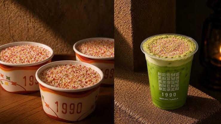 Blue and yellow swirled soft serve topped with colorful fruity cereal in a branded SIP box held against a pink wall