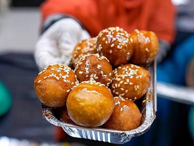 Fresh luqaimat dough balls drizzled with date syrup at a Dubai street stall