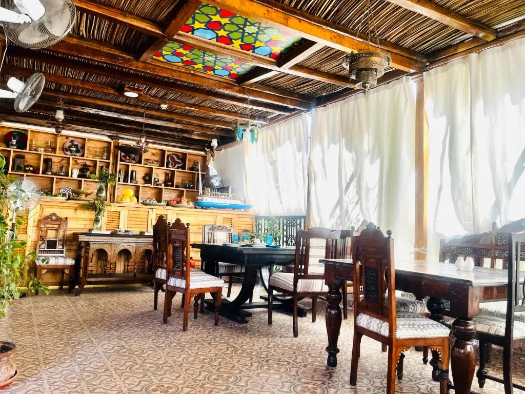 Dimly lit interior of Sofra Restaurant with a crystal chandelier, arched mirrors lined with warm Edison bulbs, and diners seated at wooden tables