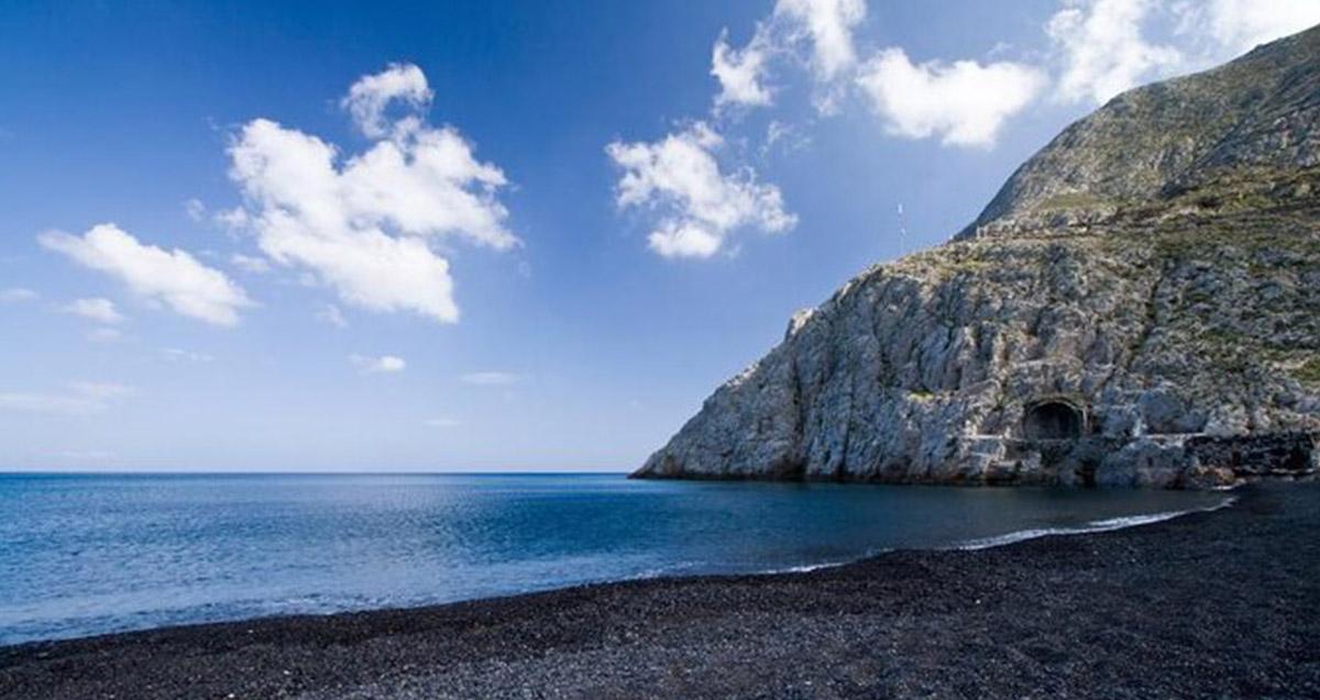 Black sand at Kamari Beach, Santorini with Mesa Vouno mountain behind