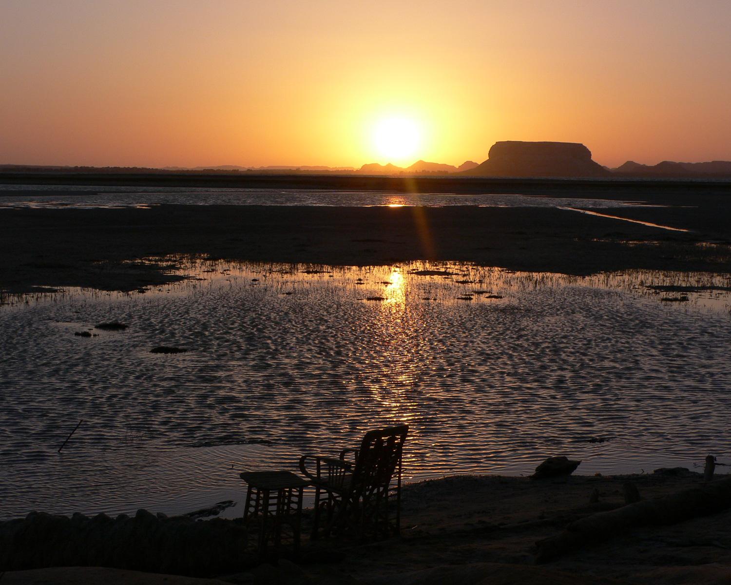 Fatnas Island at sunset with orange light reflecting off Birket Siwa salt lake
