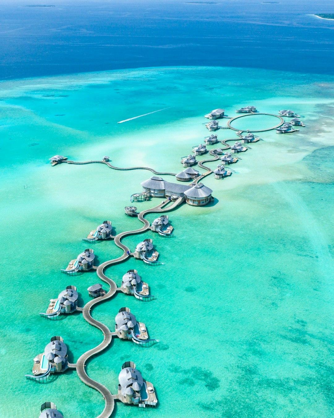 Aerial view of Maldives overwater bungalows connected by winding jetties over turquoise lagoon waters
