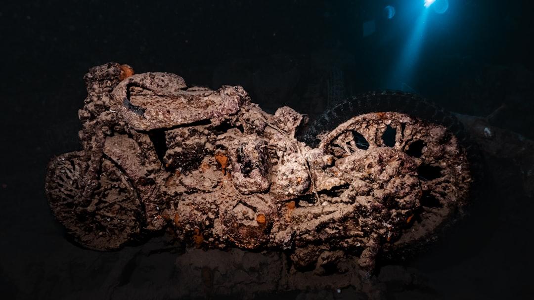 Rusty deck of a sunken shipwreck surrounded by vivid turquoise ocean under a bright blue sky