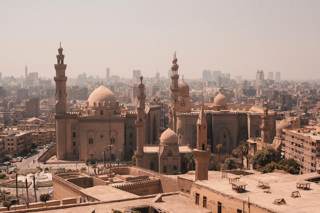 Aerial view of Sultan Hassan Mosque and Al-Rifa'i Mosque with Cairo's hazy skyline stretching behind them