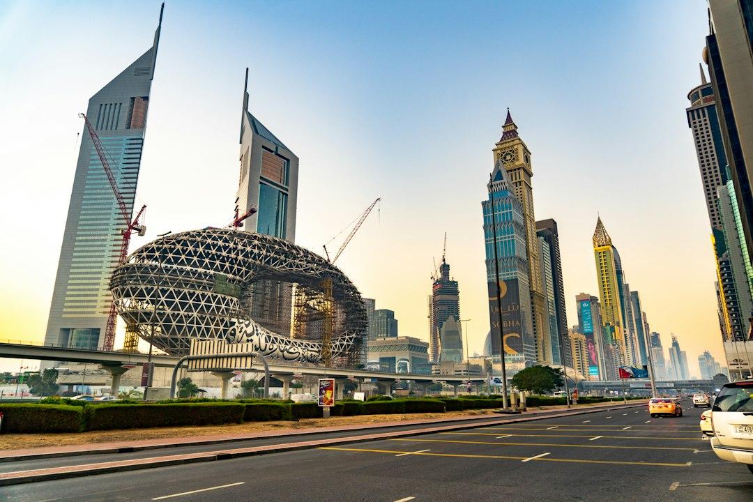 Museum of the Future under construction on Sheikh Zayed Road, Dubai, with Emirates Towers and city skyscrapers at dusk