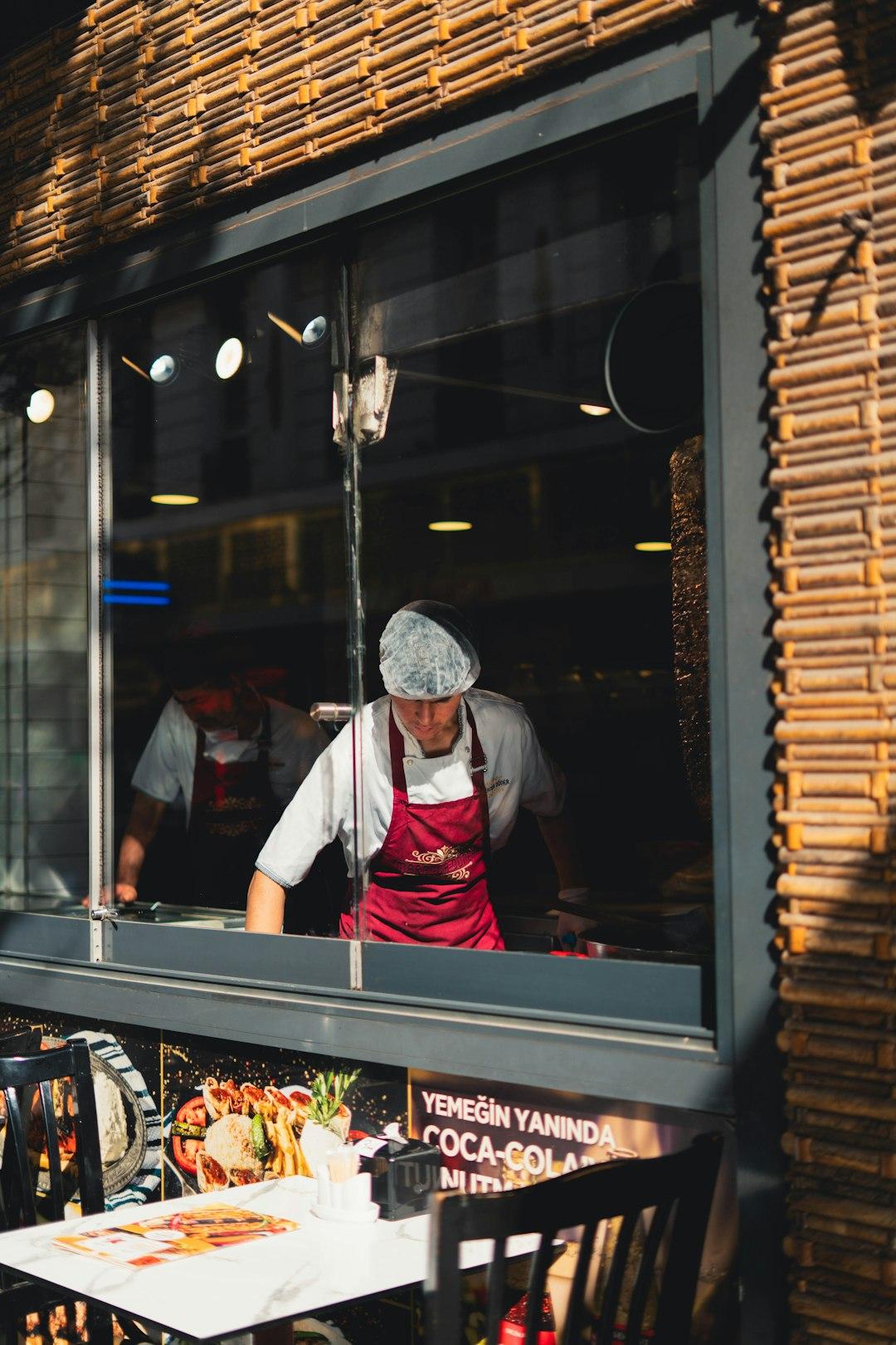 Chef in red apron and hairnet preparing doner kebab inside Kasap Osman restaurant, Sultanahmet, Istanbul